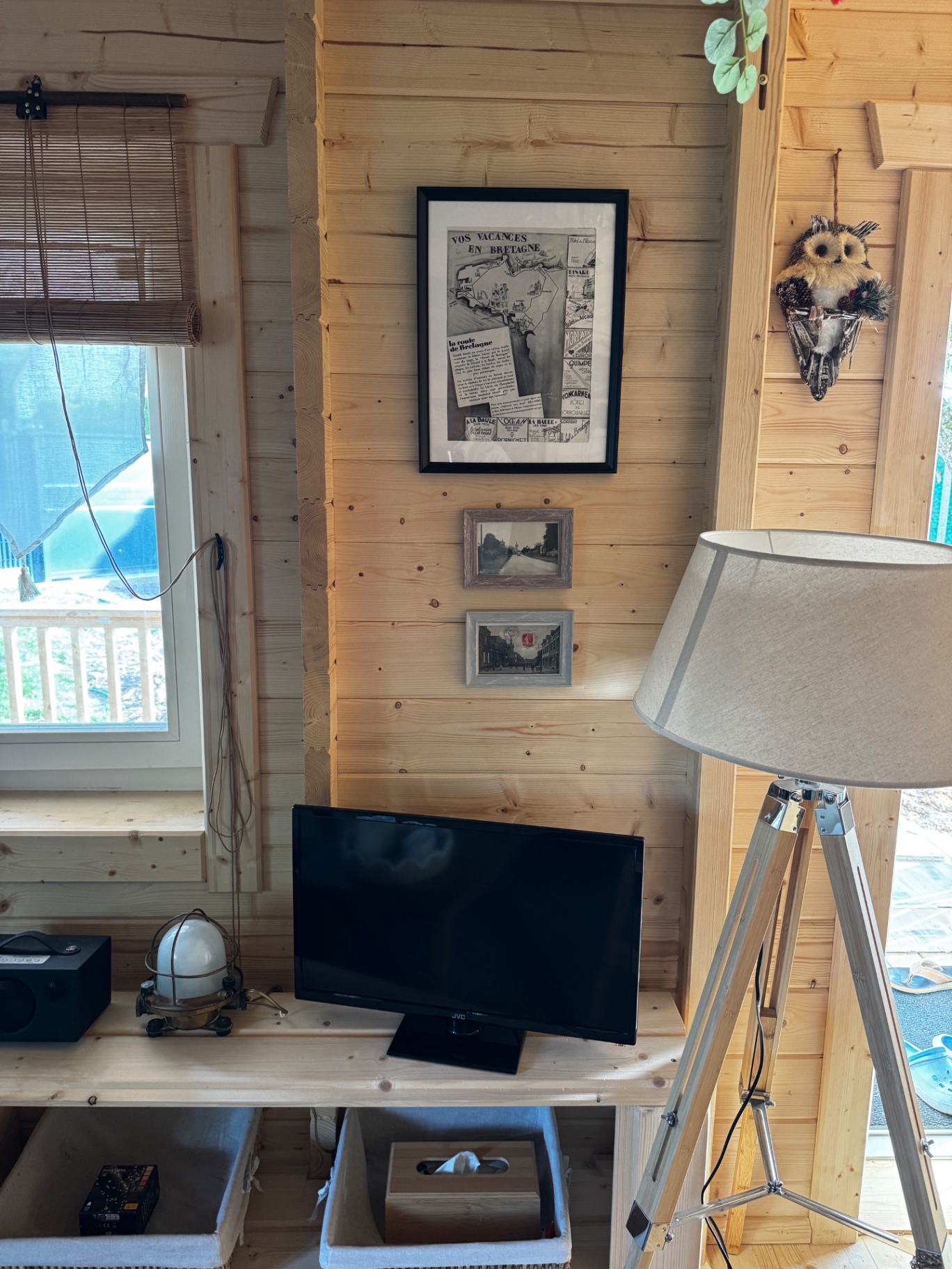 Coin TV avec lampe trépied et affiches vintage de Bretagne